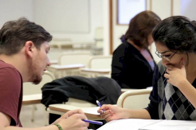 en la imagen se puede ver a dos estudiantes hablando
