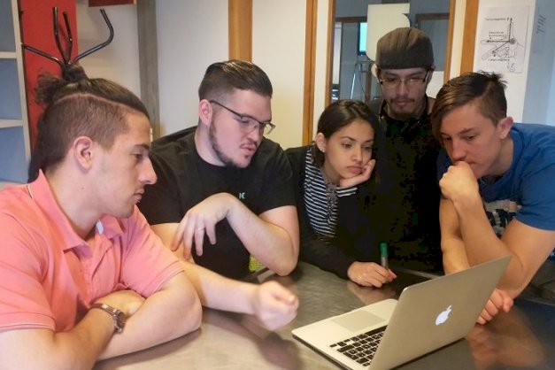 en la imagen se puede ver a estudiantes de ingenieria de la UNTDF mirando una computadora